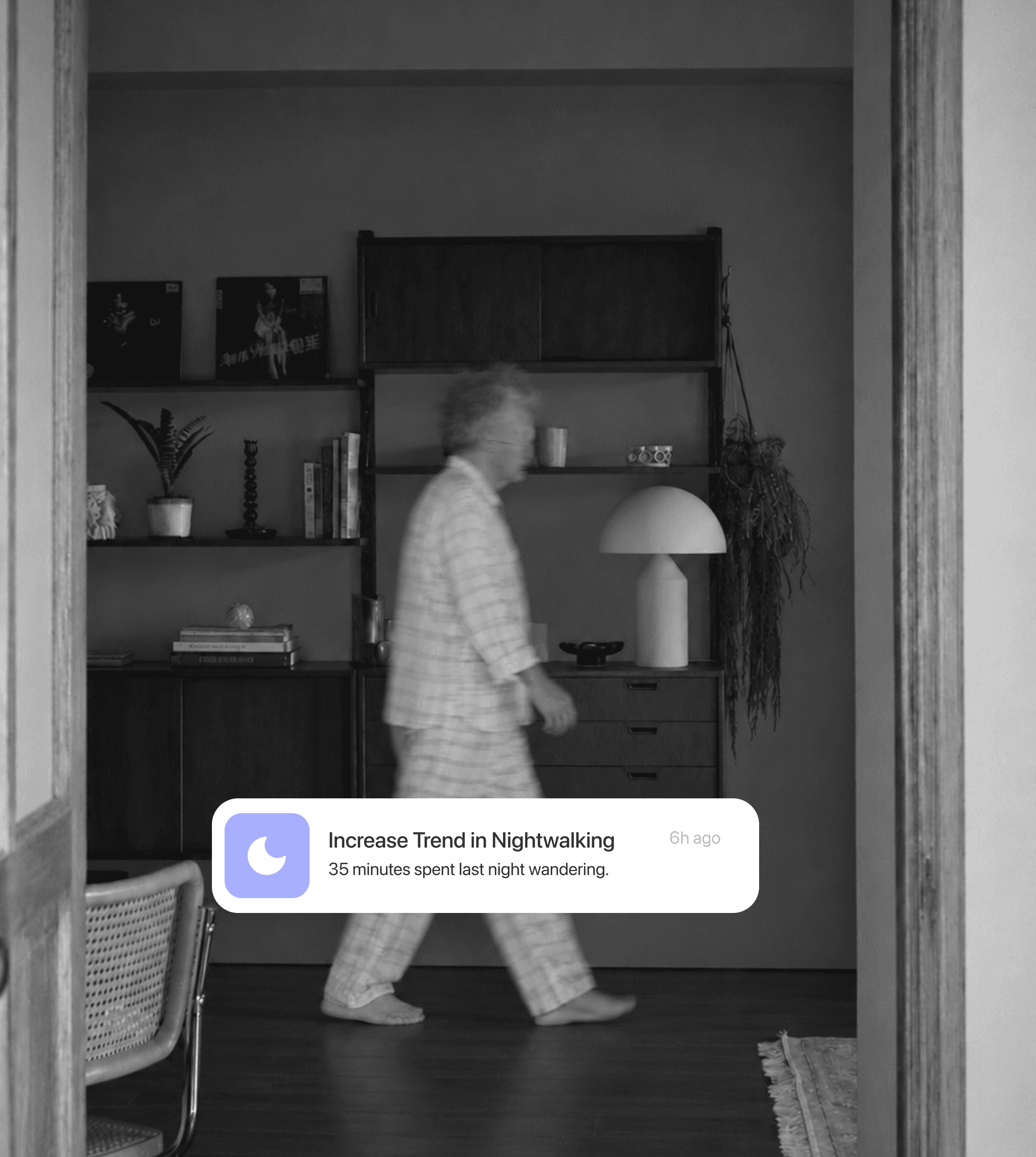 Nighttime camera view of an older adult walking through a living room with an activity update